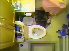 Naked maiden takes a piss in the bathroom